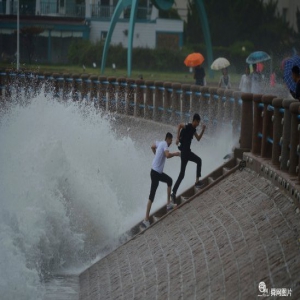 受台风影响青岛沿海现大潮 游客冒险观潮戏浪