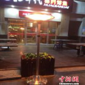 为报恩郑州餐厅老板门口设取暖器 供市民免费取暖